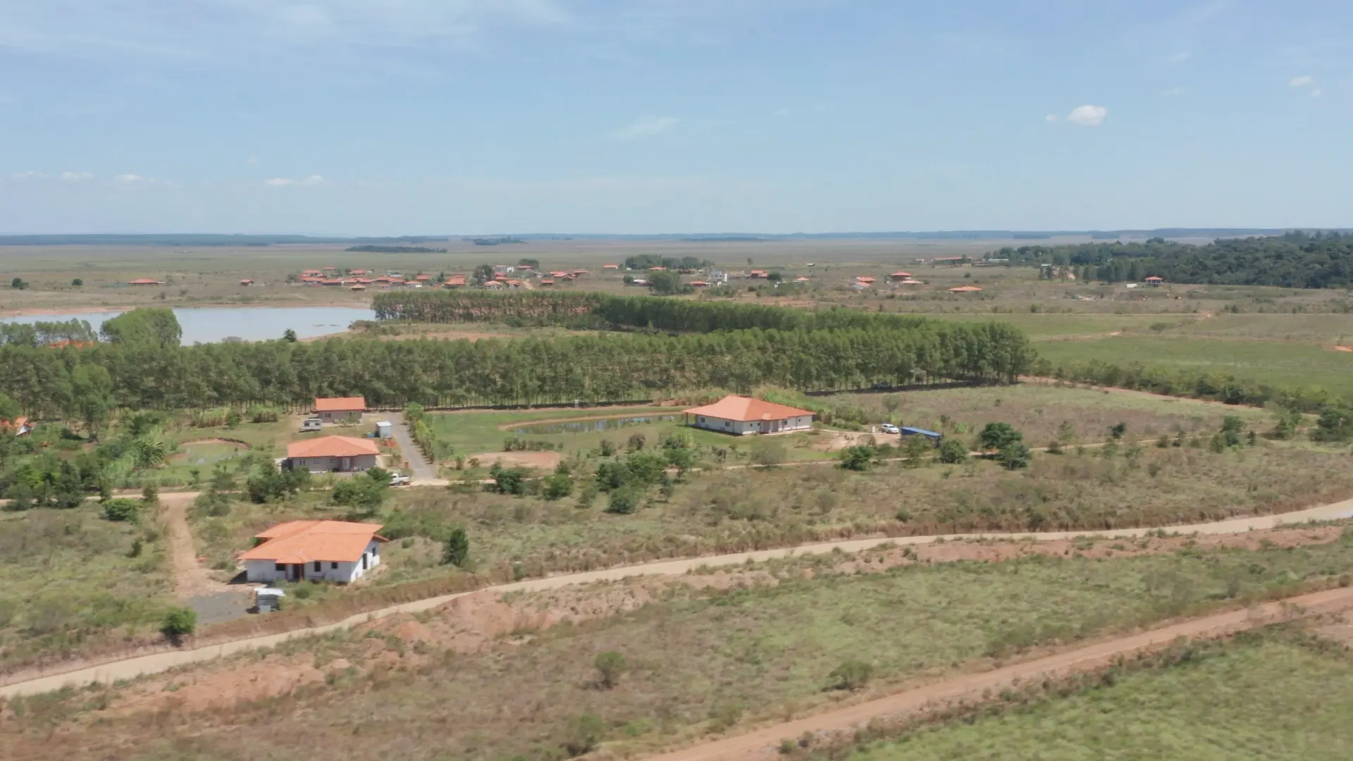 Real estate: New homes in a lush landscape with trees and a large lake in the background.
